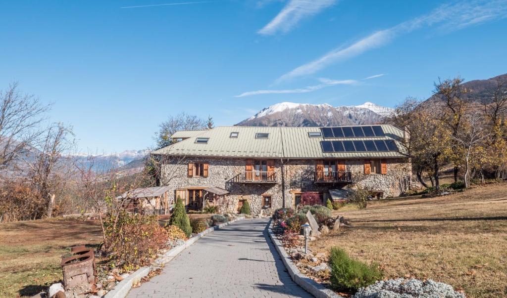 ein großes Steinhaus mit Sonnenkollektoren darauf in der Unterkunft La Fernande in Baratier