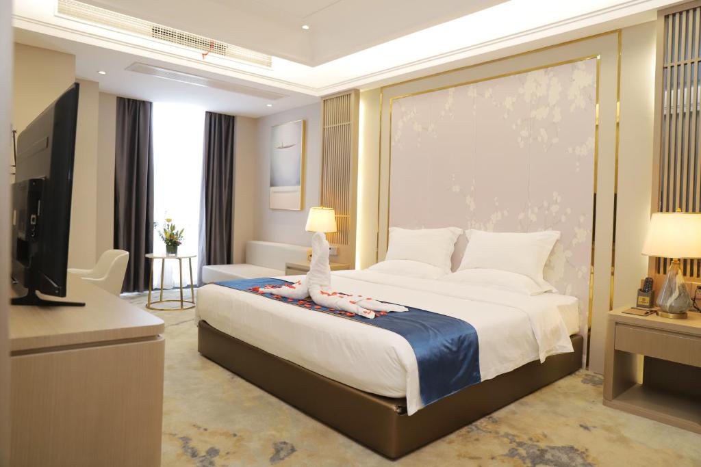 a hotel room with a bed and a television at Five Elephants Hotel in Sihanoukville