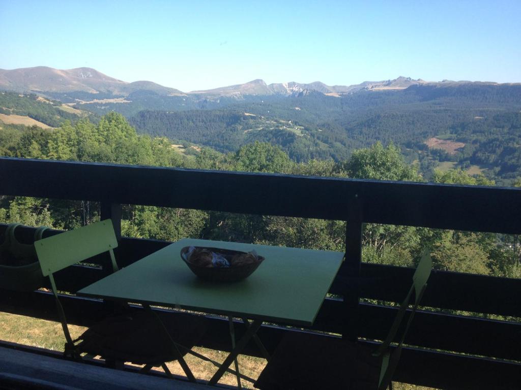 Una mesa en un balcón con vista a las montañas. en Duplex Superbe Vue Montagne, en La Bourboule