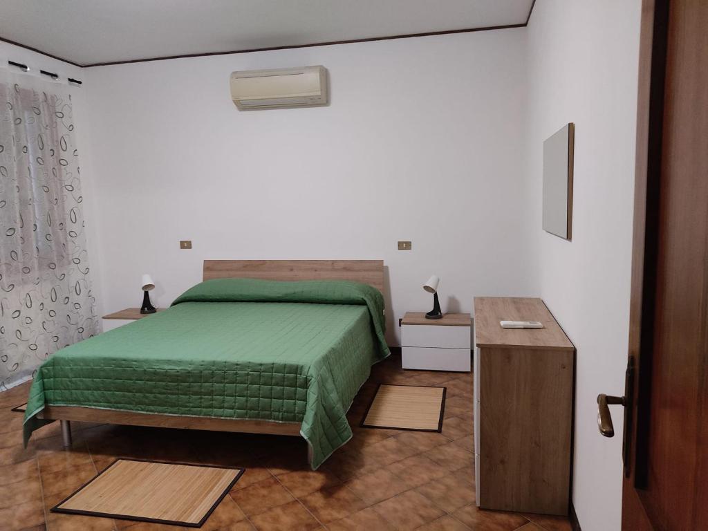 1 dormitorio con cama verde y mesa de madera en Locanda di Cornoleda, en Cinto Euganeo