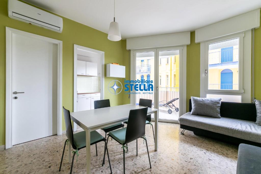 - un salon avec une table, des chaises et un canapé dans l'établissement Condominio Commerciale, à Lido di Jesolo