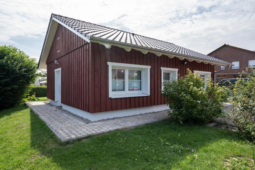 a red house with a white window in a yard at Alte Da h me Haus 2 in Dahme