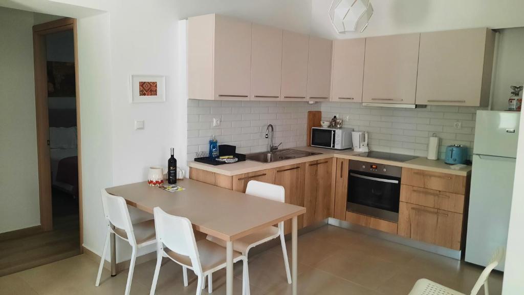 kuchnia z drewnianym stołem i białymi urządzeniami w obiekcie Ismini Apartments Myrtos w mieście Myrtos