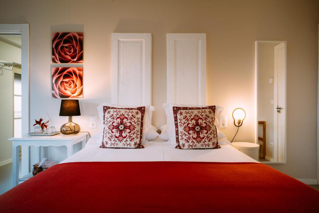 a bedroom with a red and white bed with two pillows at el gran sueño Boutique Hotel & Apartamentos - Adults Only in Pintueles