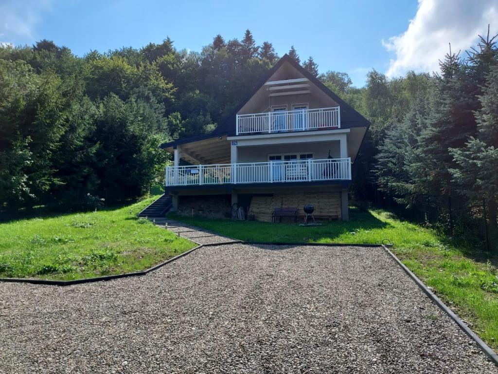 a house on a hill with a gravel driveway at DOM PIOTRUSIÓWKA NAD ZALEWEM KLIMKÓWKA in Klimkówka