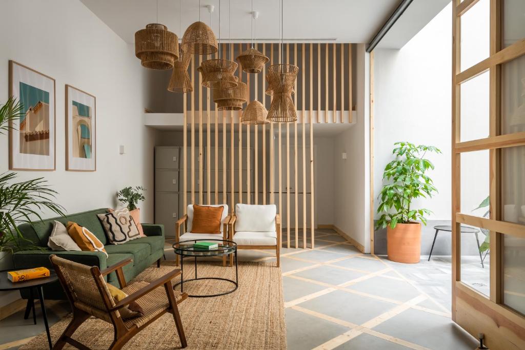 a living room with a green couch and chairs at BYPILLOW La Sal in Cádiz