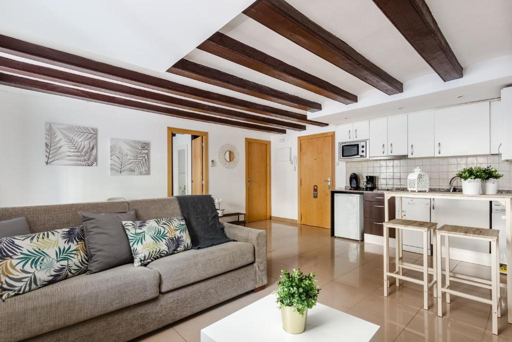ein Wohnzimmer mit einem Sofa und einer Küche in der Unterkunft Lodging Apartments Liceu 11 in Barcelona