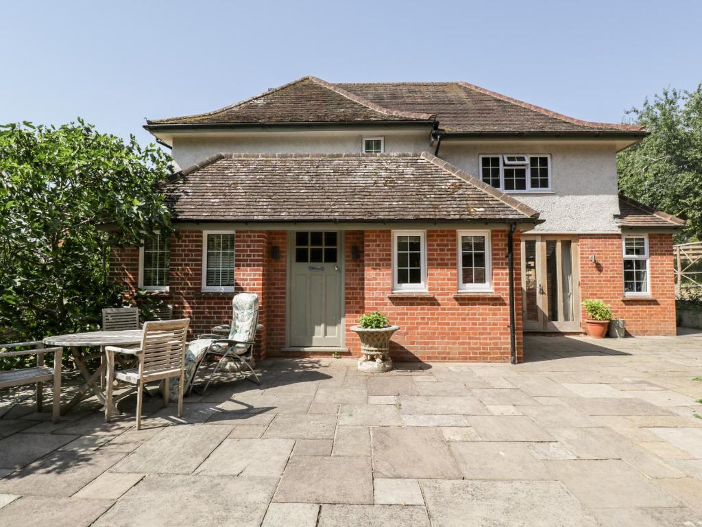 a brick house with a table and chairs at Gardeners Cottage in Hungerford