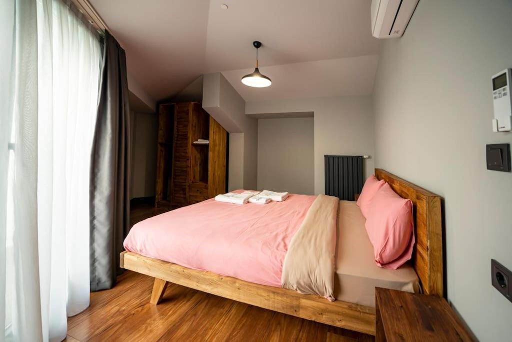 a bedroom with a large bed with pink sheets at Superior, classy residence,7&#47;24 Security,2 bedroom ( Benesta 205 ) in Istanbul