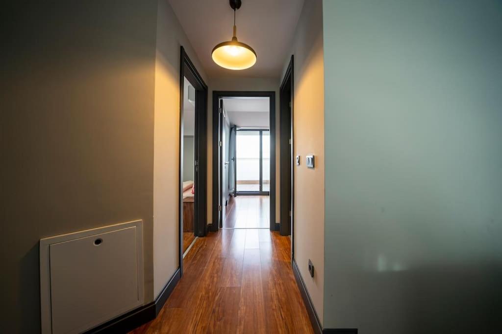 a hallway of an apartment with wooden floors and a light fixture at Superior, classy residence,7&#47;24 Security,2 bedroom ( Benesta 205 ) in Istanbul