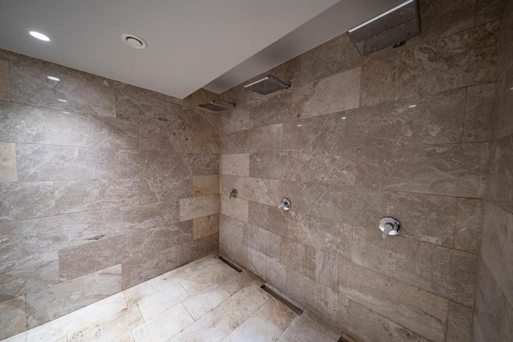 a bathroom with a shower with a stone wall at Superior, classy residence,7&#47;24 Security,2 bedroom ( Benesta 205 ) in Istanbul