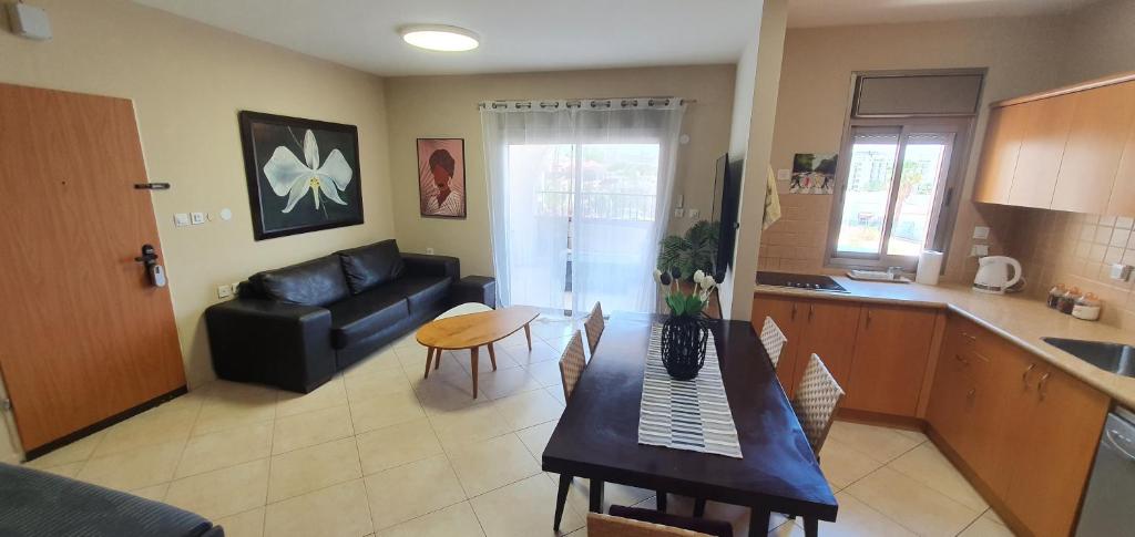 a kitchen and living room with a table and a couch at Riviera palace Eilat in Eilat