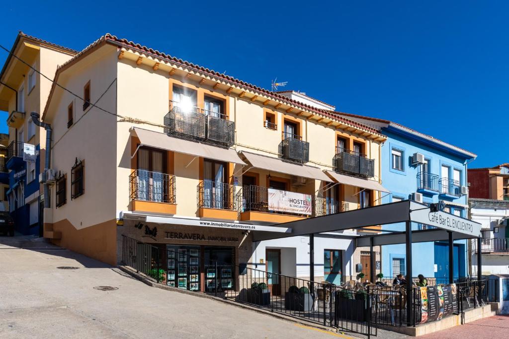 a building with people sitting outside of it at Albergue El Encuentro in Villanueva de la Vera