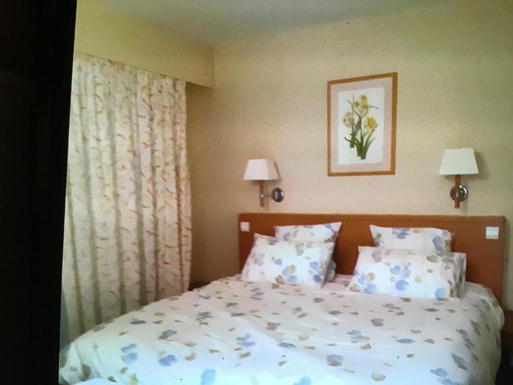 1 dormitorio con 1 cama con almohadas azules y blancas en 2p sur le golf de La Baule 