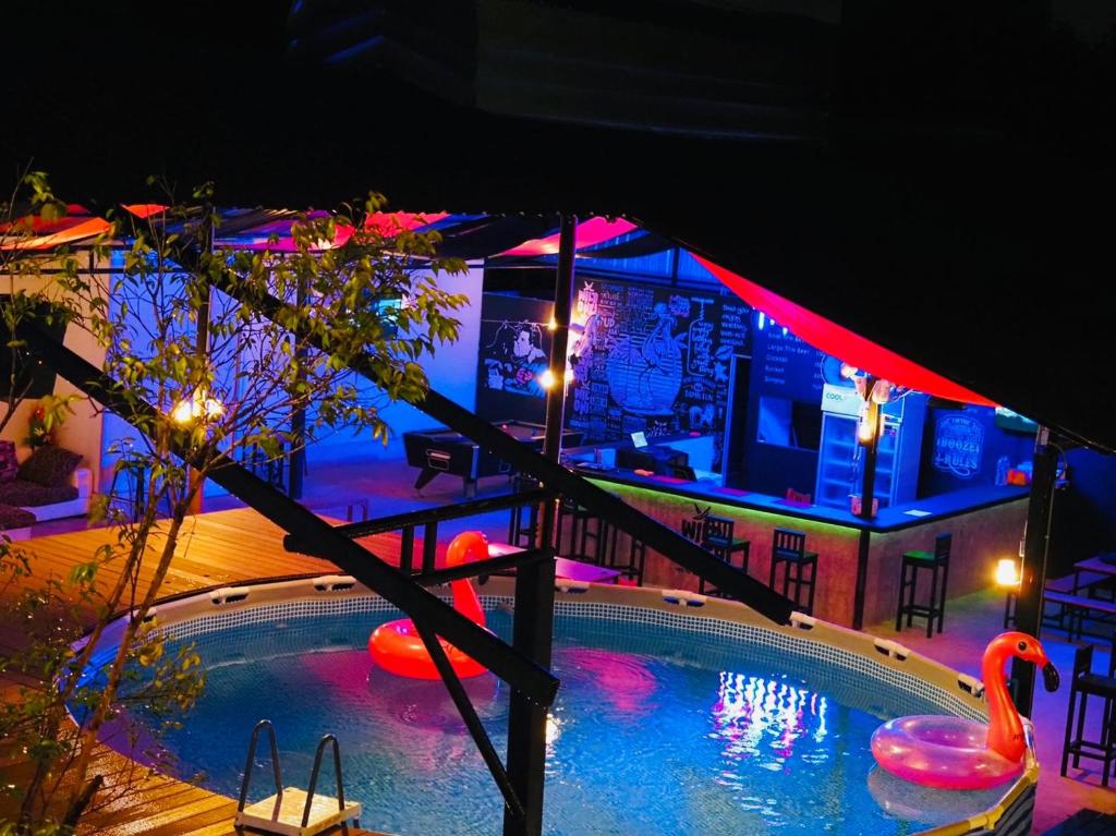 una casa con piscina por la noche en Wild Ones Hostel, en Bangkok