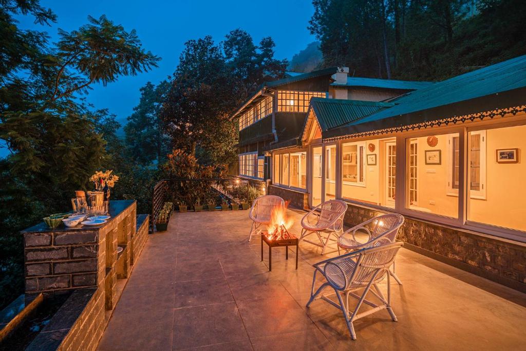 a patio with chairs and a table with a fire pit at StayVista at Springfield with Scenic Lawn in Kasauli
