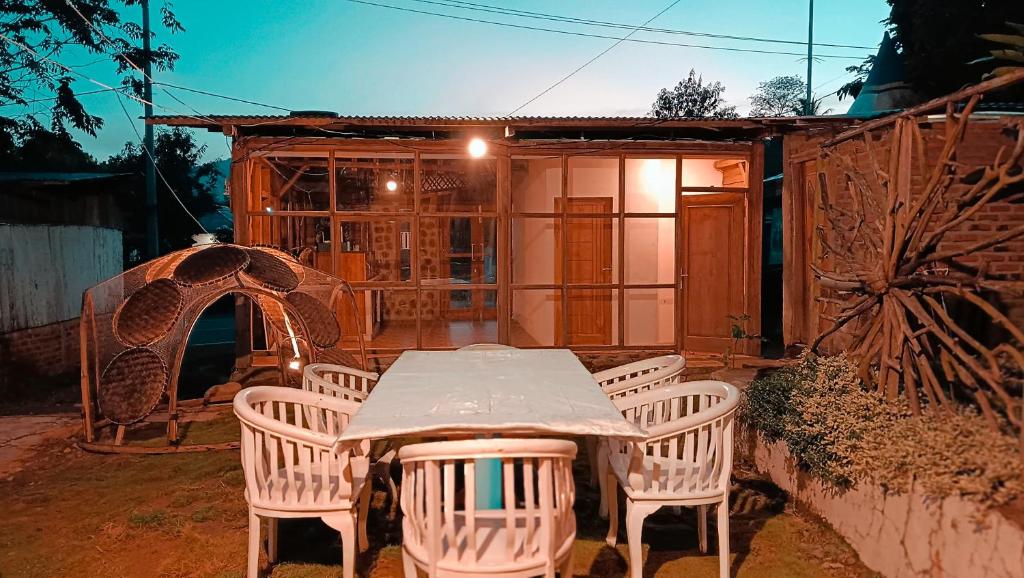 un tavolo e sedie di fronte a una casa di Lontart Guesthouse a Nggorang