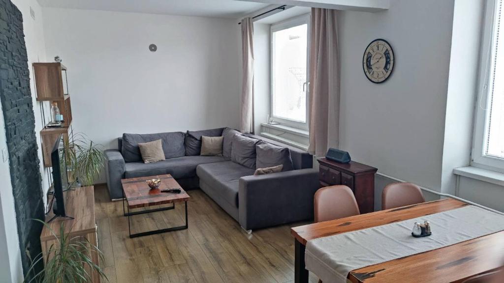 een woonkamer met een bank en een tafel bij Moderný byt s krbom a klimatizáciou in Prešov