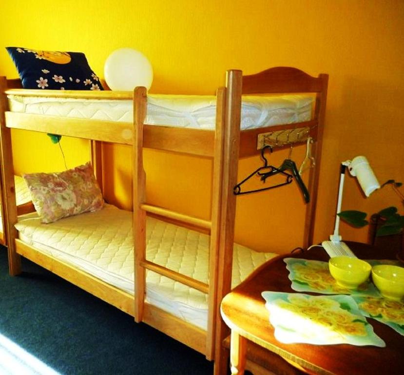 2 Etagenbetten in einem Zimmer mit einem Tisch in der Unterkunft YourHostel Club in Kiew
