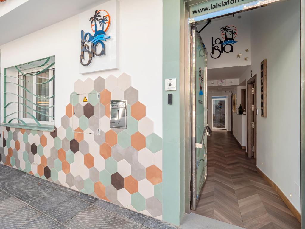 un pasillo con una pared geométrica en un edificio en La Isla , tu hogar en Torre del Mar. en Torre del Mar