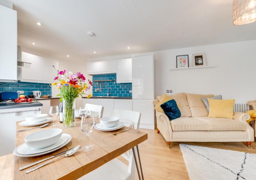 a kitchen and living room with a table and a couch at An Rannji in Penzance