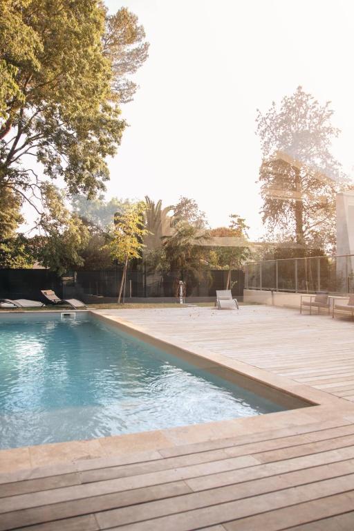 una piscina en un patio con terraza de madera en T3 30 dans résidence neuve près des plages, en Saint-Cyr-sur-Mer