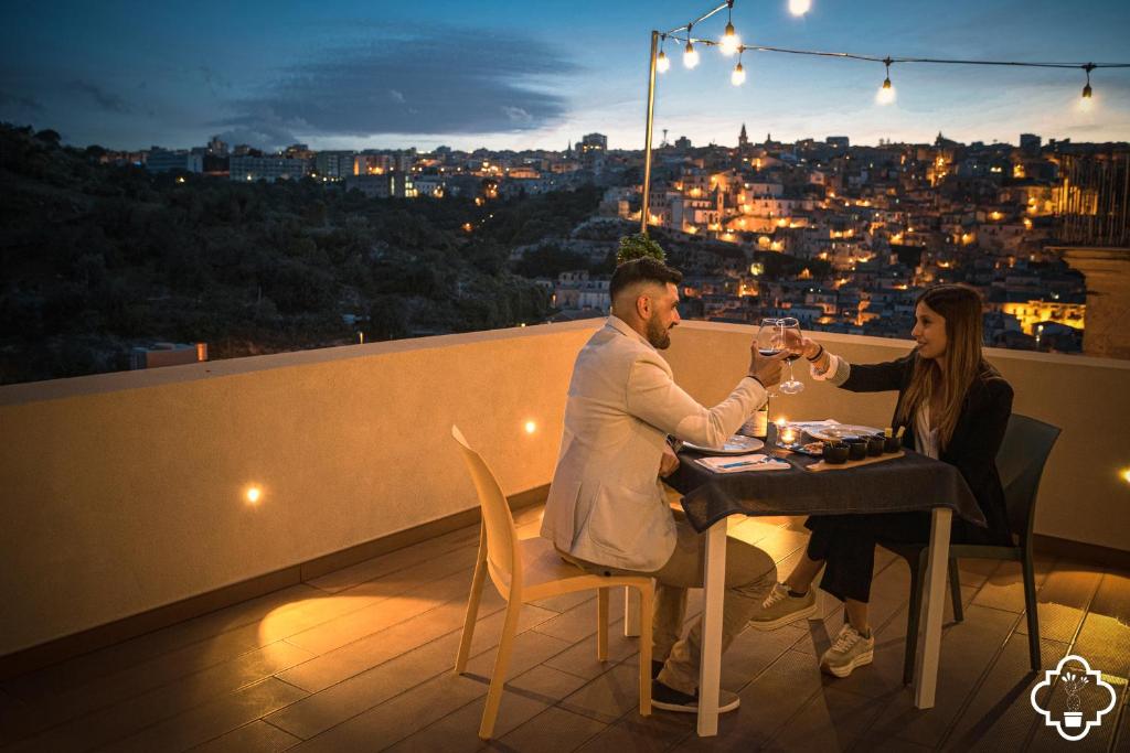 a man and woman sitting at a table with wine glasses at Fico - Finestra Contemporanea in Ragusa