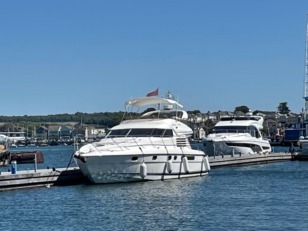 dos barcos están atracados en un muelle en el agua en Tranquility Yachts -a 52ft Motor Yacht with waterfront views over Plymouth. en Plymouth