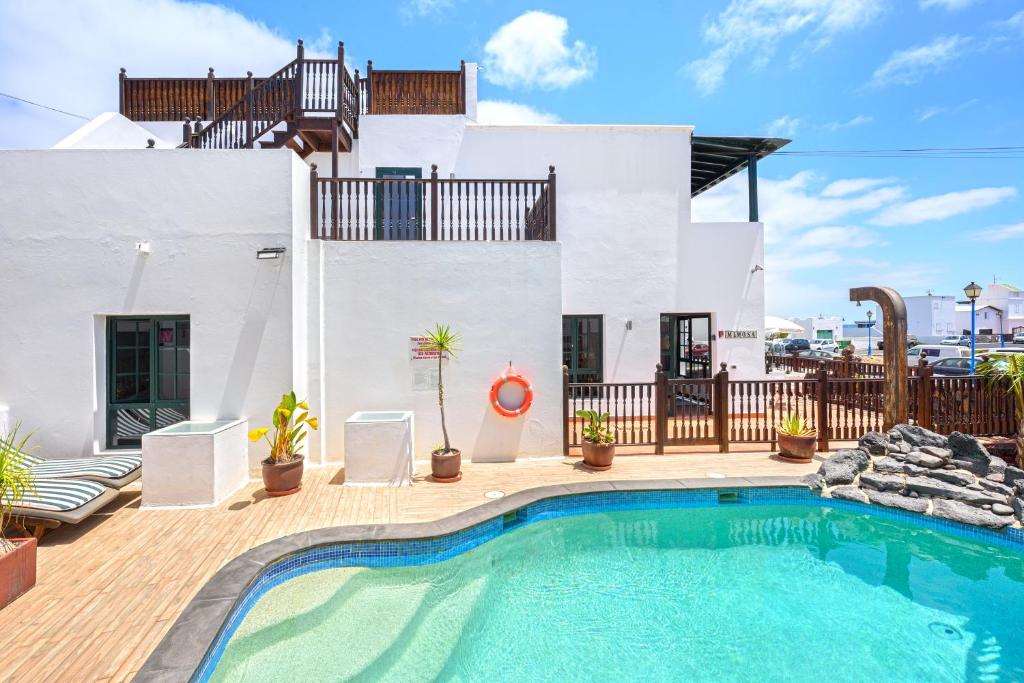 una piscina frente a una casa en Lanzahost Villa Mimosa en Punta de Mujeres