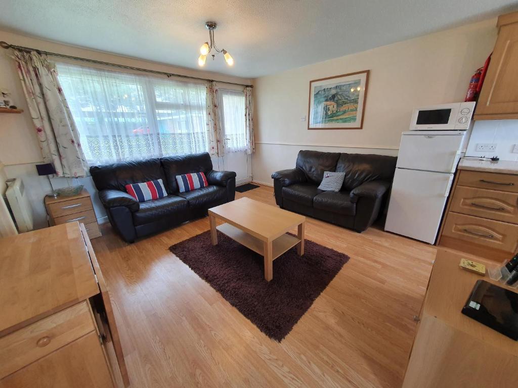 a living room with a couch and a table at Lovely 5 Berth Chalet In Hemsby Nearby Great Yarmouth Ref 73034c in Hemsby