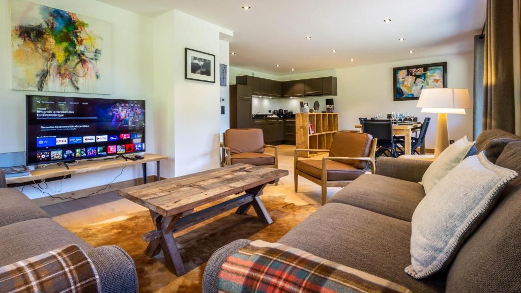 a living room with a couch and a tv at Appartement Green in Chamonix