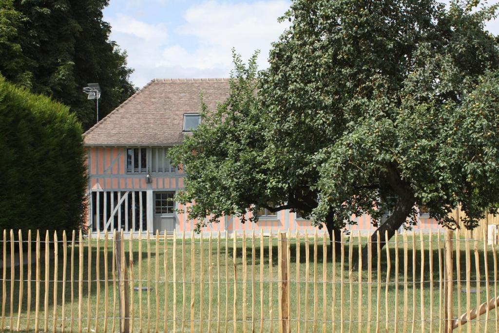 una cerca frente a una casa con un árbol en Gîte Le Pic Drille, en Charmont-sous-Barbuise
