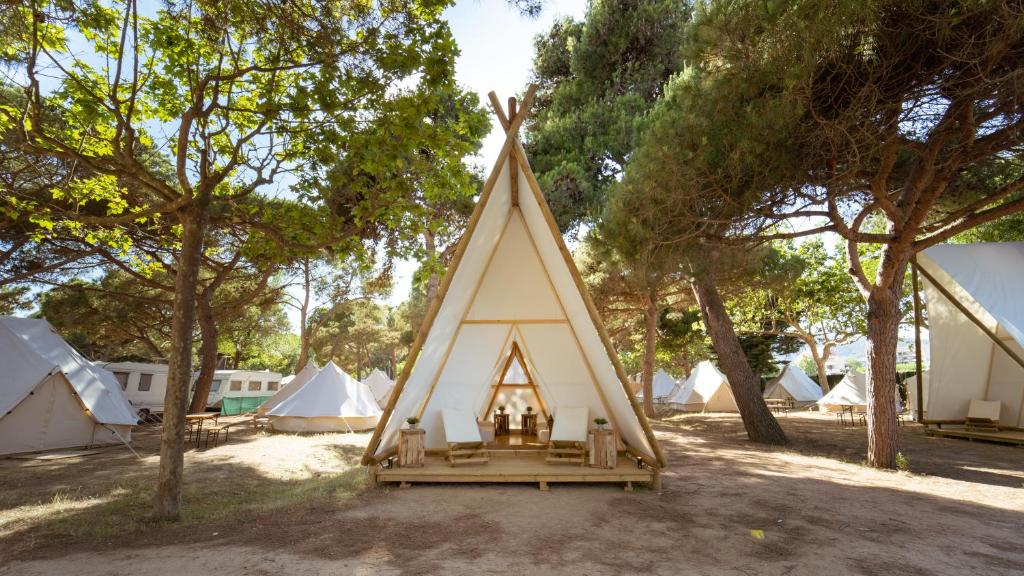 una tienda tipi en un campo con muchas tiendas de campaña en Kampaoh Platja d'Aro, en Platja d'Aro