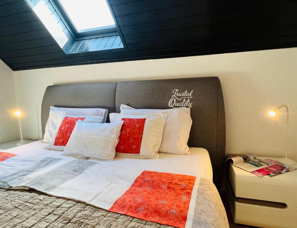 a bedroom with a large bed with red and white pillows at Heviz Apart Comfort in Hévíz