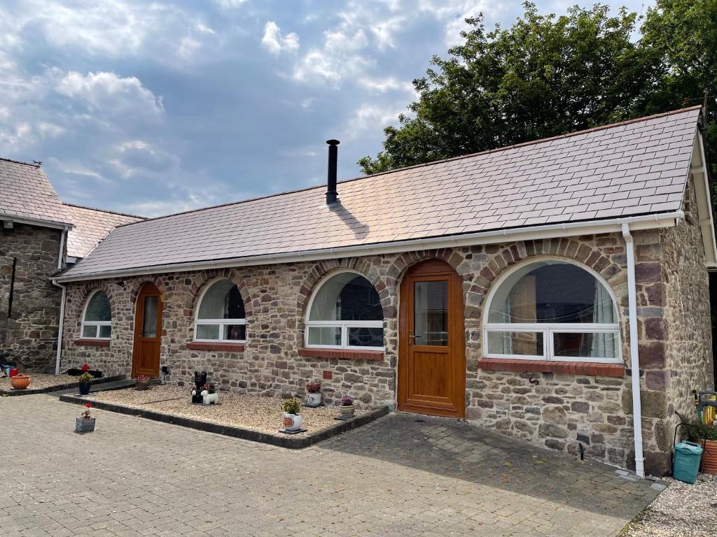 a brick house with a brown door and windows at Red Kite Barn in Ammanford