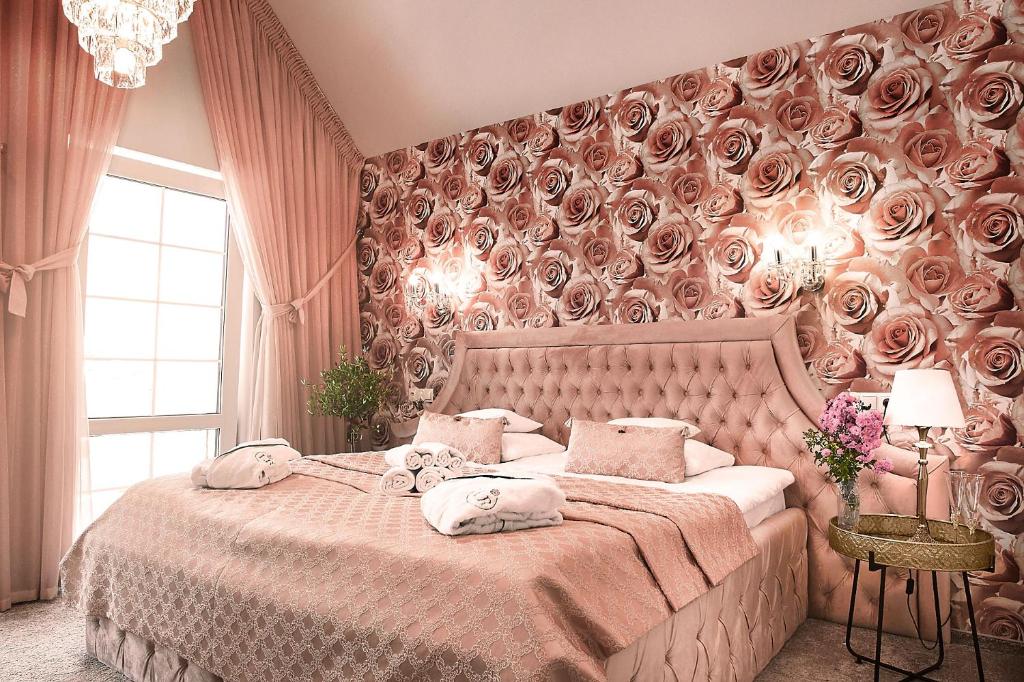 a bedroom with a large bed with a wall covered in roses at La Rose Residence in Mikołajki