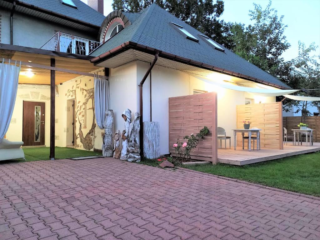 Cette maison dispose d'une terrasse et d'une table dans la cour. dans l'établissement Pensjonat Pocztówka, à Zgierz