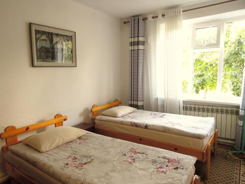 a bedroom with two twin beds and a window at Arthouse in Karakol