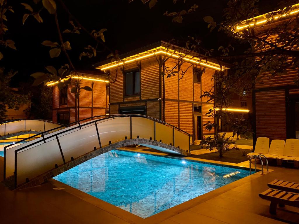 uma piscina em frente a um edifício à noite em ZK Wooden Village em Sapanca