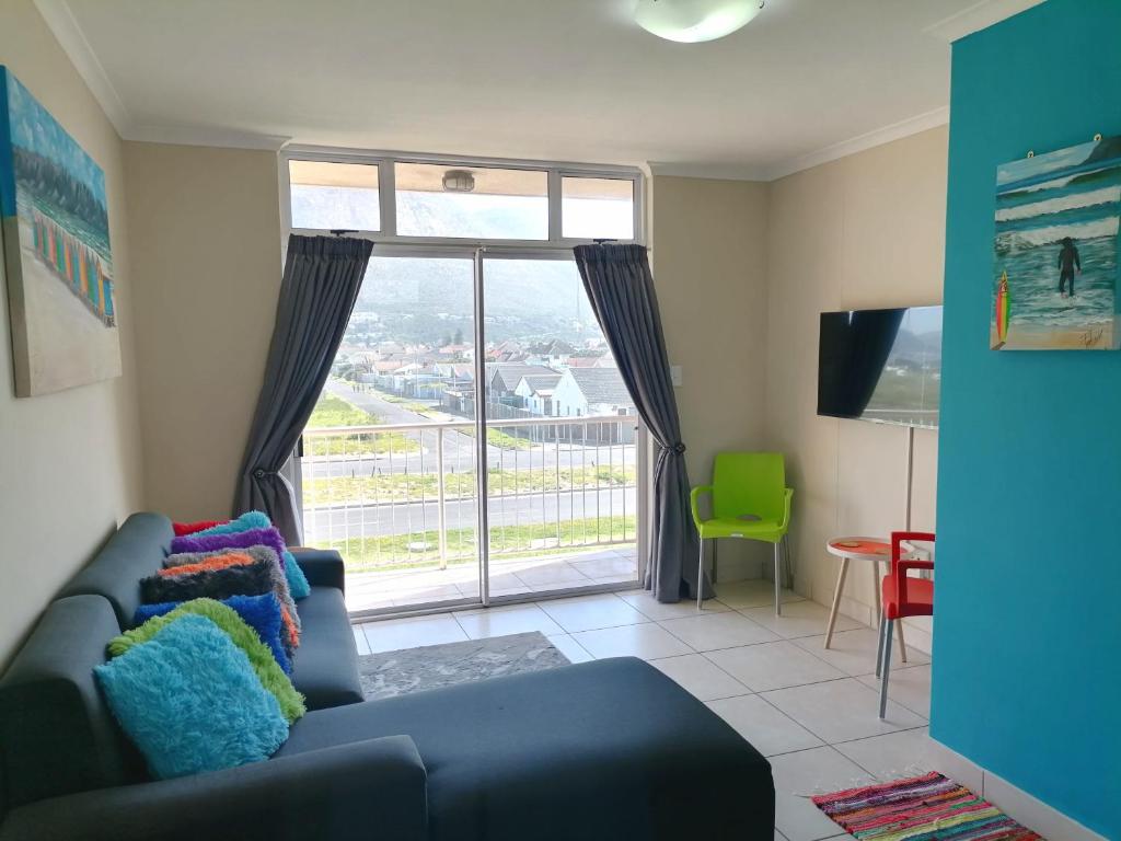 ein Wohnzimmer mit einem Sofa und einem großen Fenster in der Unterkunft Muizenberg Mountain View Apartment in Kapstadt