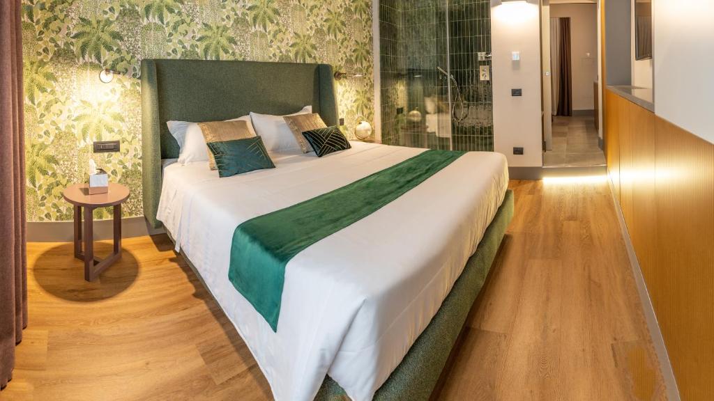 a large bed with a green headboard in a bedroom at Castel Sant´Angelo Luxury Rooms & Tour in Rome