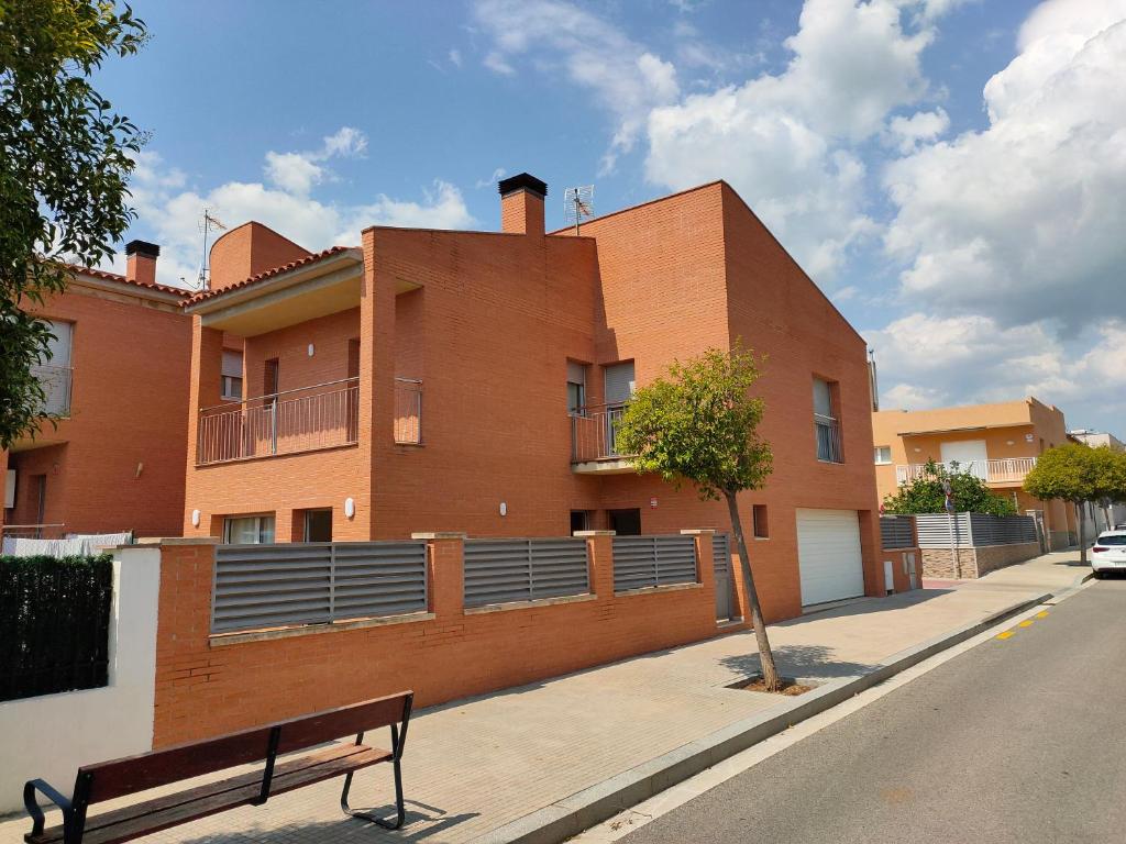 budynek na ulicy z ławką przed nim w obiekcie Chalet amplio con Jardín y zona barbacoa. w mieście Reus