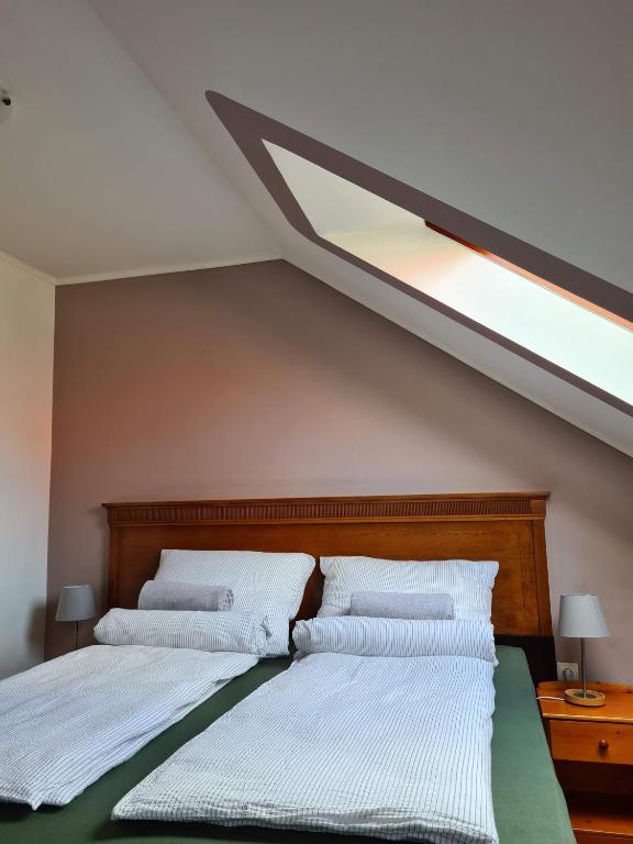 A bed or beds in a room at Palantír Panzió