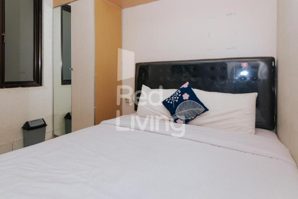 a bed with white sheets and pillows in a room at Columbus Residence J10 near RSUD Karawang Mitra RedDoorz in Karawang