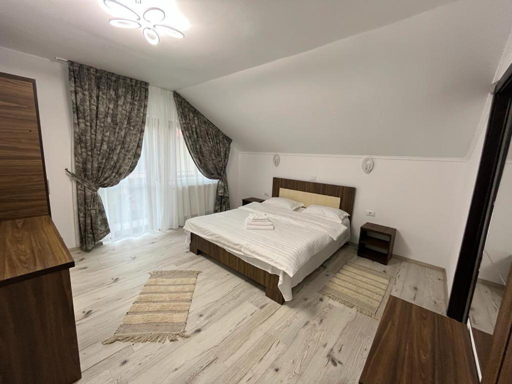 a bedroom with a bed in a room with wooden floors at Casa Marci Teo in Moieciu de Jos
