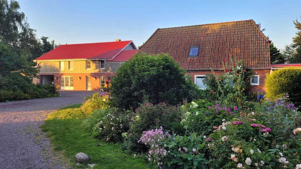 una casa con techo rojo y jardín en Landhof Osterdeich en Emmelsbüll-Horsbüll