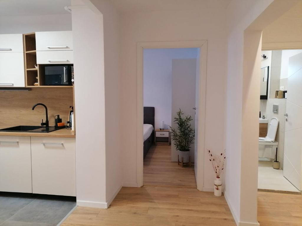 uma cozinha e sala de estar com armários brancos em Bethlen Apartman em Odorheiu Secuiesc