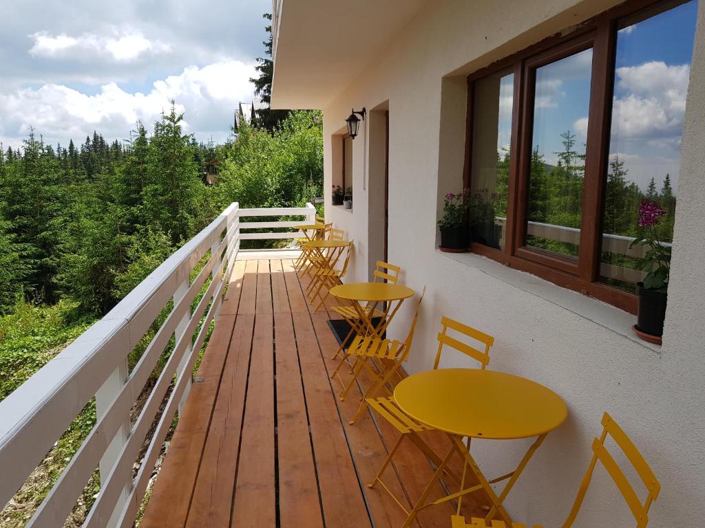 einen Balkon mit Tischen und Stühlen sowie einem Fenster in der Unterkunft Casa Bunicutei in Ranca