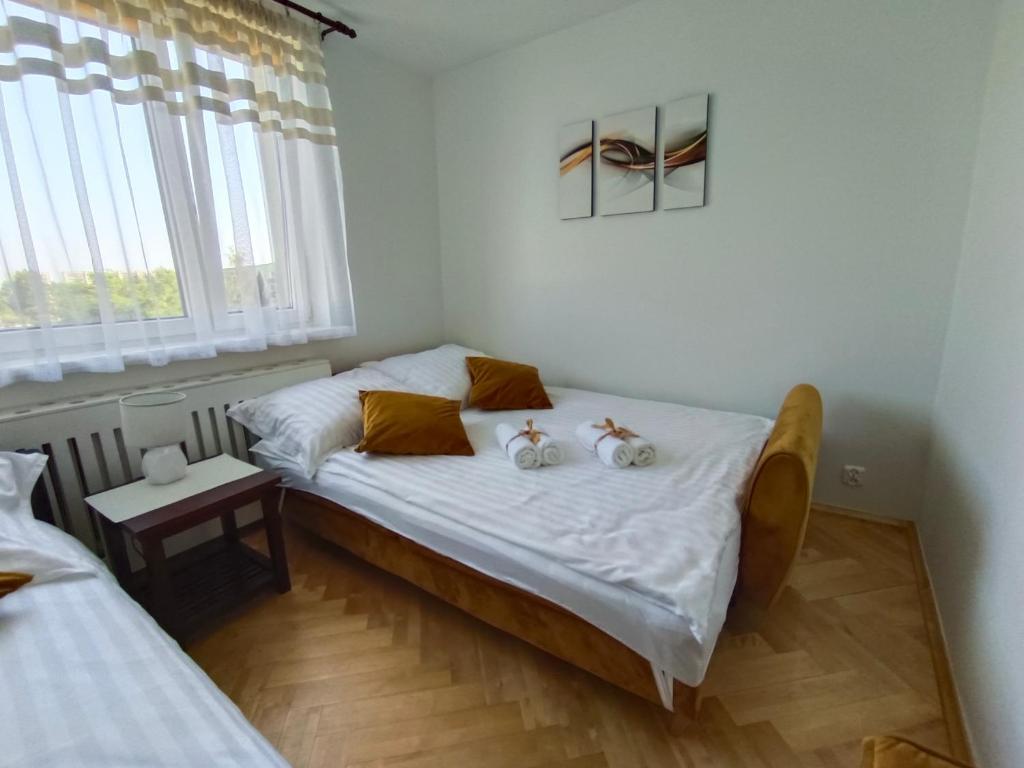 dois bichos de peluche sentados numa cama num quarto em Relax Apartment Suwałki em Suwałki