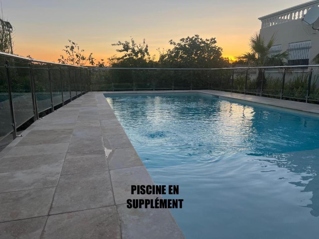 uma piscina com um pôr-do-sol ao fundo em App T2 a Montpellier em Montpellier